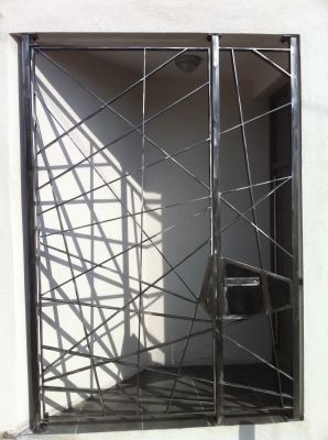 fabrication et pose d'une grille de sécurité moderne en acier brut d'atelier avec une finition vernis par nos soin à Marseille